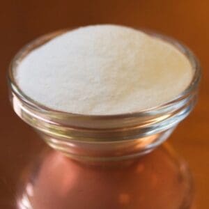 A glass bowl of white powder on top of a table.