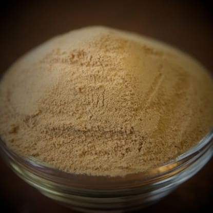 A bowl of brown powder on top of a table.