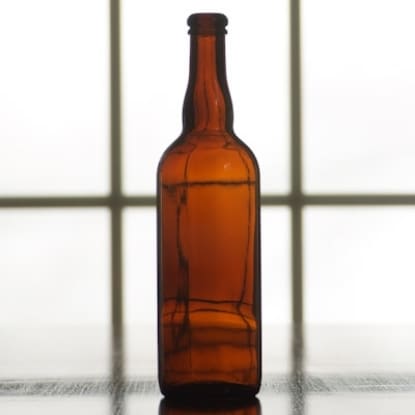 Empty amber glass beer bottle.