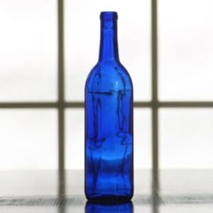 Blue glass wine bottle on table.