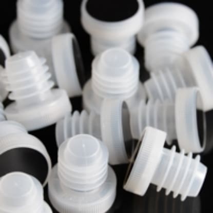 White plastic bottle stoppers on black background.