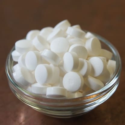 White round pills in glass bowl.