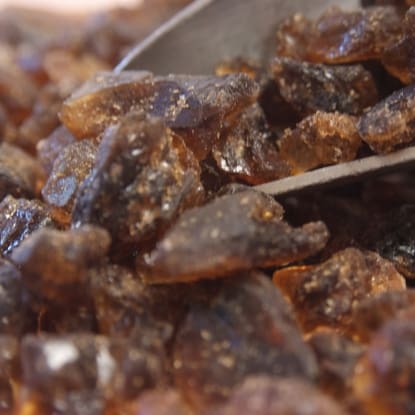 A spoon full of brown sugar sitting on top of some food.