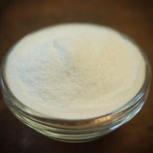 A glass bowl of white powder on top of a table.