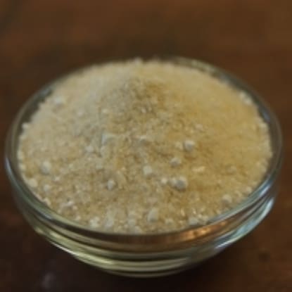 A glass bowl of white powder on top of a table.