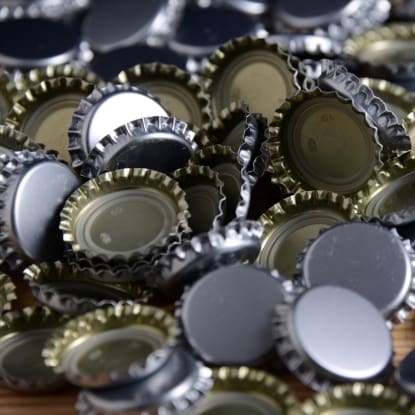 Pile of silver and gold bottle caps.