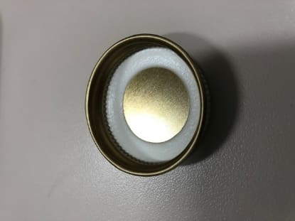 Gold bottle cap with white liner.