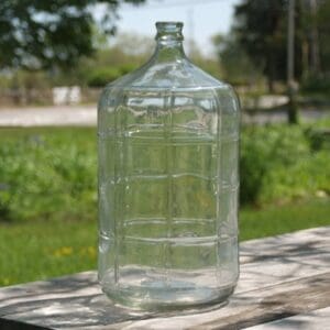 Large empty glass water bottle.