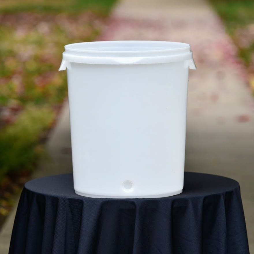 White plastic bucket on black tablecloth.